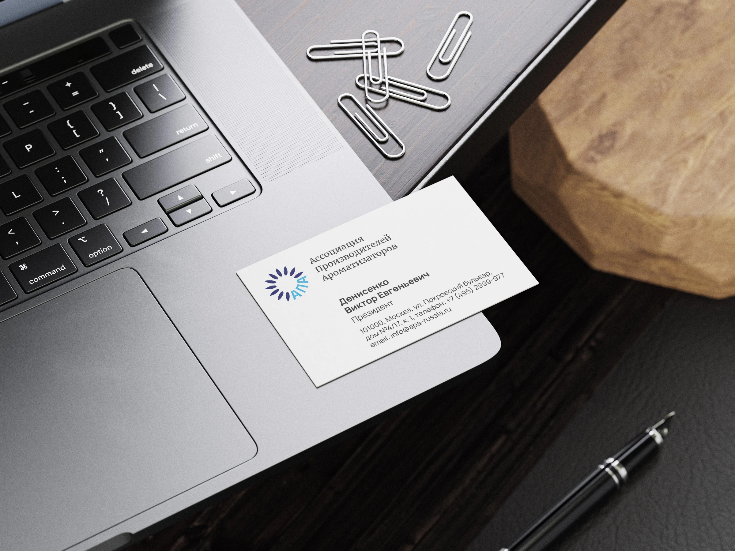 APA business card beside a laptop and notebook