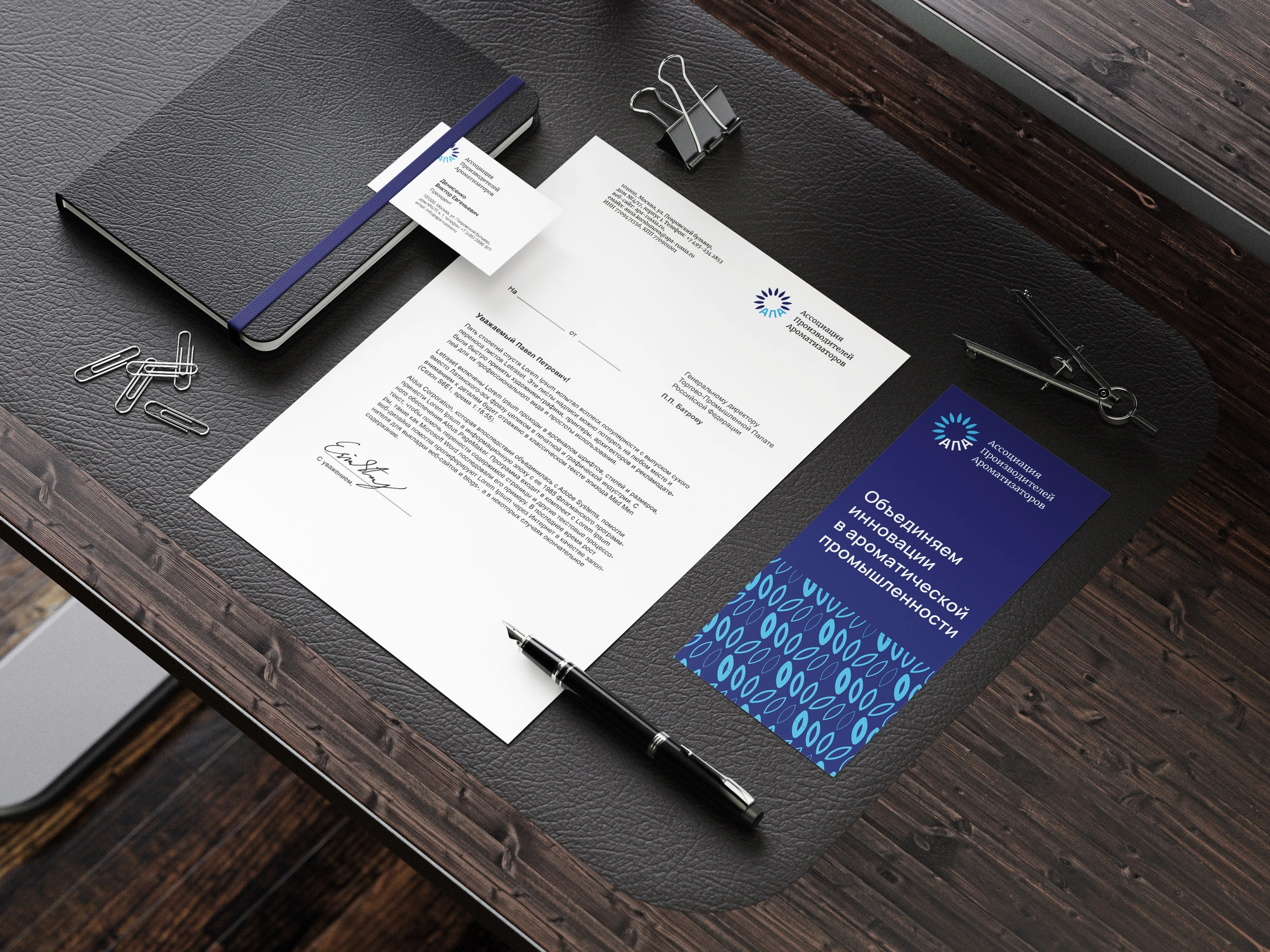 APA identity on a folder, letterhead and business cards, with a blue sunflower symbol and petal patterns