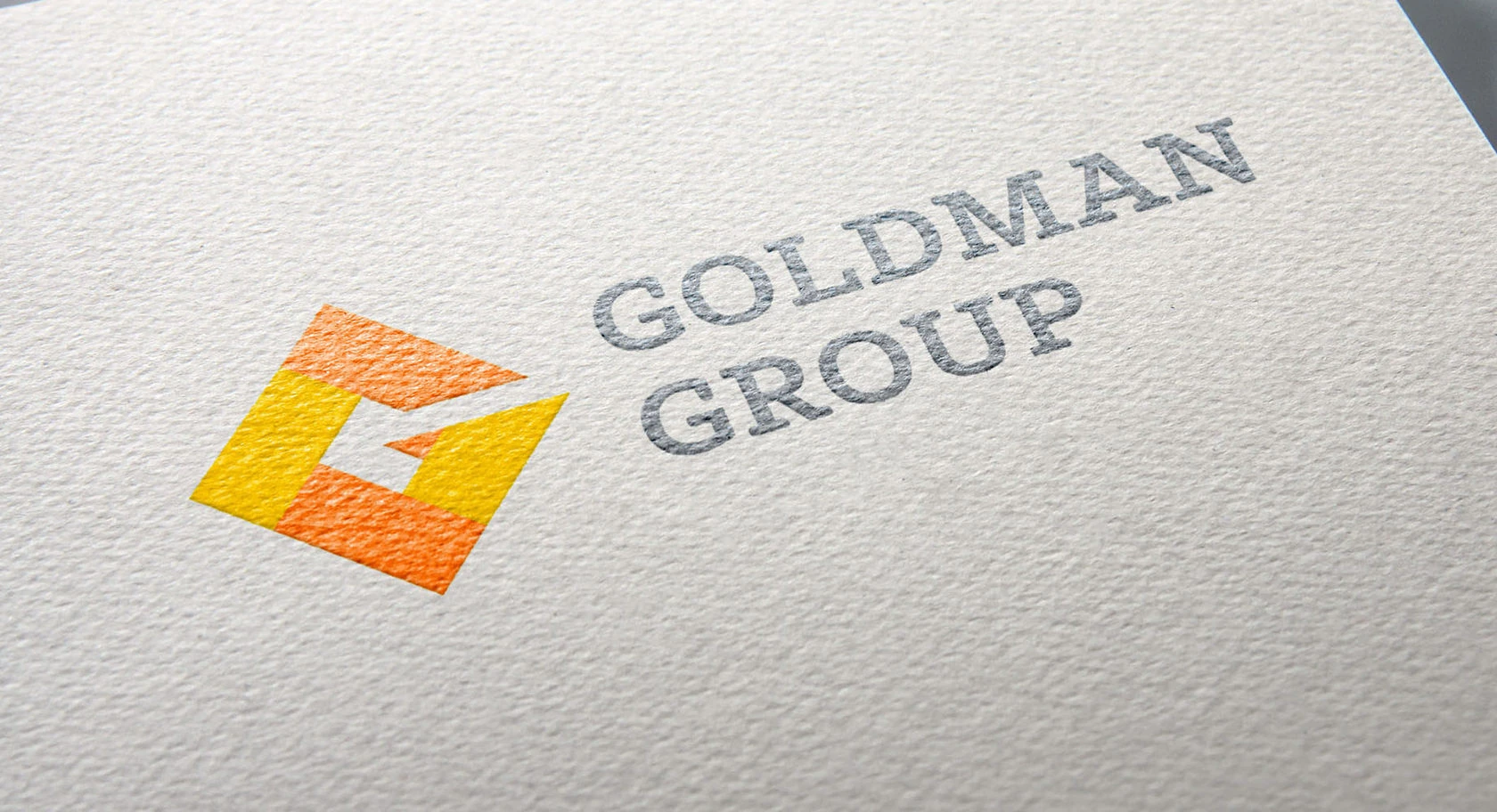 Original Goldman Group yellow G mark and wordmark printed on textured paper
